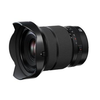 Black wide-angle zoom lens with hood attached, shown at three-quarter angle against white background.