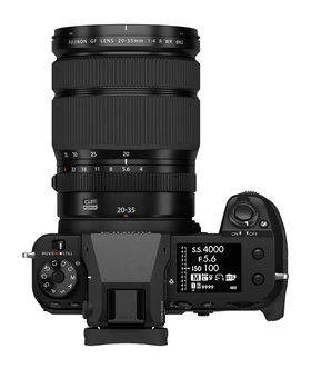 Top-down view of a mirrorless camera with a telephoto lens and articulating rear screen extended.