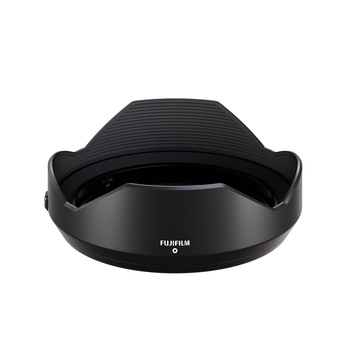 Black Fujifilm lens hood with curved petal design and ribbed interior against white background.