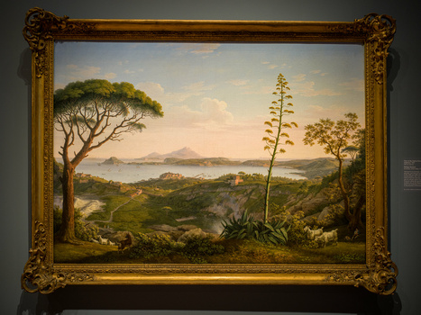Ornate oil painting depicting a lush tropical landscape with towering agave plant and distant mountains across water.