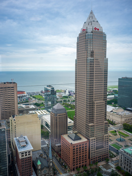 Tall art deco skyscraper with distinctive crown overlooking a waterfront city.