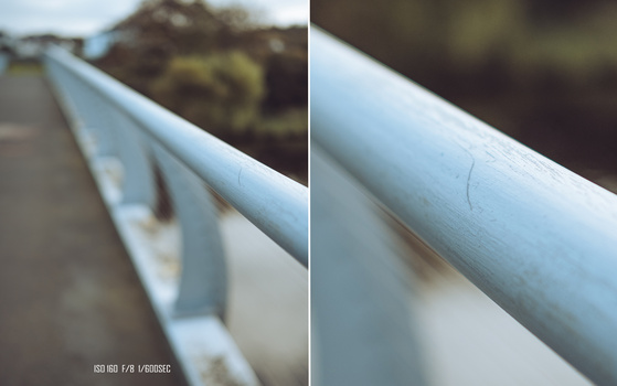 Close-up comparison of a metal handrail or pipe showing surface texture and detail from two slightly different perspectives and focal distances.