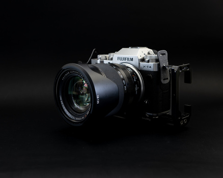 Fujifilm GFX medium format camera with prime lens on dark background.