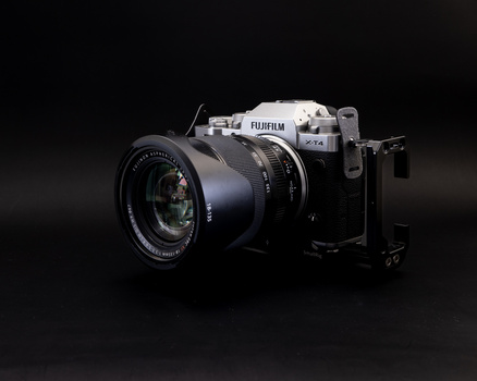 Fujifilm mirrorless camera with attached prime lens against a dark background.