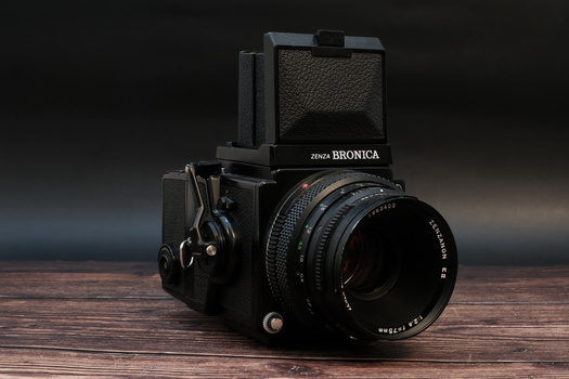 Zenza Bronica medium format camera with waist-level viewfinder and Carl Zeiss lens on wooden surface.