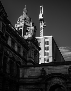 Historic domed cathedral and modern radio tower photographed in high-contrast black and white.