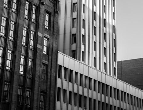 Black and white photograph of modernist buildings with geometric facades and rows of windows.