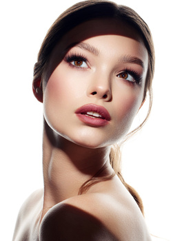Woman's face with professional makeup and soft studio lighting against white background.