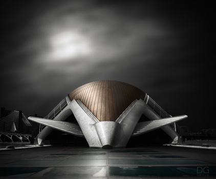 Modern architectural structure with symmetrical curved metal wings against dramatic cloudy sky.