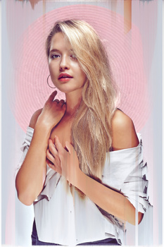 Woman with long blonde hair wearing white off-shoulder top against pink circular backdrop.