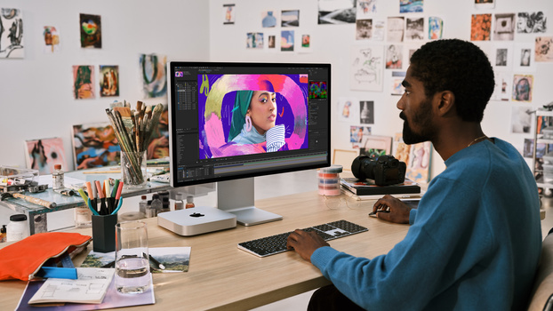 Designer working on colorful portrait illustration in editing software on desktop monitor.