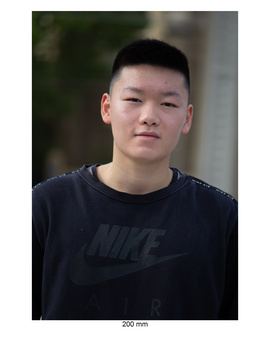 Young man in dark Nike t-shirt looking directly at camera with neutral expression.