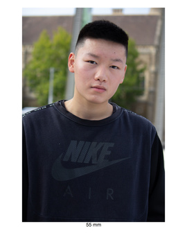 Young man in black Nike t-shirt looking directly at camera with neutral expression.