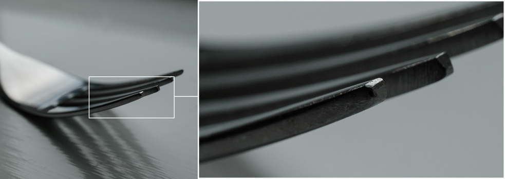 Close-up detail of a frayed black cable end showing internal wire strands and damage.