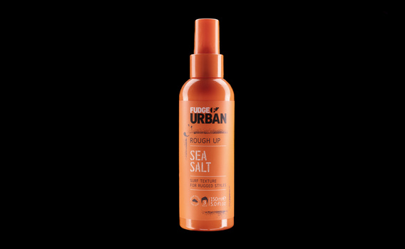 Orange spray bottle with white and black label text against black background.
