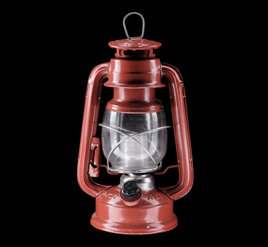 Red vintage-style lantern with glass panels and wire bail handle against black background.