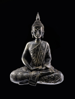 Buddha statue in meditation pose with detailed ornamentation against black background.
