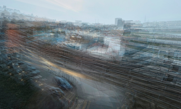 Multiple exposure of riverside industrial area with overlapping architectural layers and blurred motion creating abstract composition.