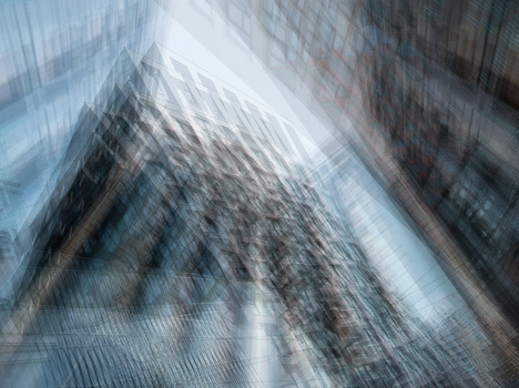 Multiple exposure abstract composition of tall buildings shot upward with motion blur and layered translucent overlays.