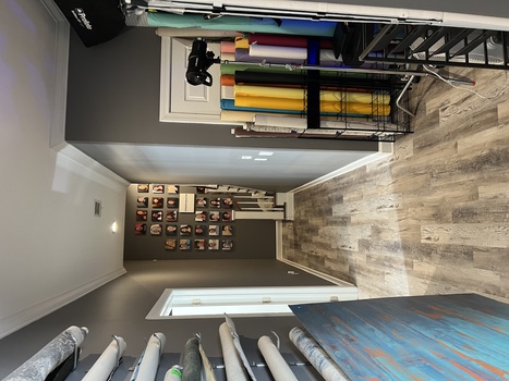 A well-organized photography studio hallway with storage shelves, lighting equipment, and colored gels on display.