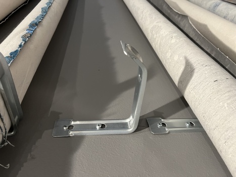 Chrome handle mounted on gray interior panel with hardware visible and bright natural light casting shadows.
