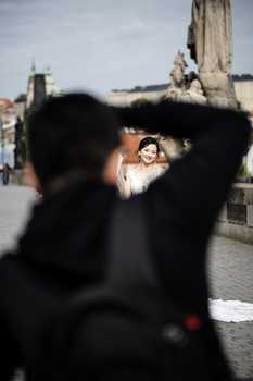 Couple kissing in sharp focus while silhouetted figures frame the shot in the foreground.