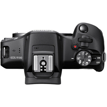 Top-down view of Canon EOS R100 mirrorless camera with flash hot shoe and mode dial visible.