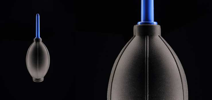 Two dark gray rubber bulbs with blue tubes against black background, showing size comparison.