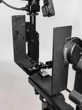 DIY camera rig with mounted camera and lighting equipment on black metal frame.