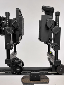 Two professional camera rigs mounted on a horizontal rail system against a neutral background.
