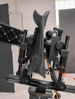 Overhead view of a professional camera rig with multiple lenses, modifiers, and support equipment arranged in a studio setup.