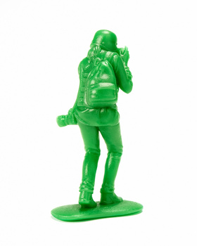 Bright green toy soldier figure standing at attention with rifle and ammunition belt.