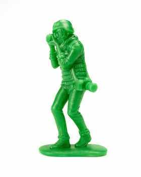 Bright green translucent plastic action figure in dynamic pose with hands raised near face.