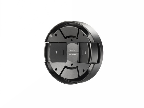 Rear view of a circular camera lens filter or adapter ring with segmented black sections and central mounting hardware.