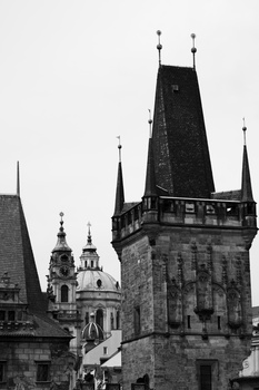 Gothic towers with ornate spires and crenellated rooflines silhouetted against a light sky in black and white.