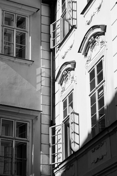 Black and white photograph of historic building facades with ornate architectural details and multiple windows.