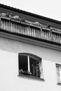 Black and white architectural photograph of a modernist building facade with a window and balcony.