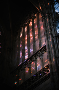 Ornate architectural columns illuminated by dramatic warm and cool lighting in a dark interior space.