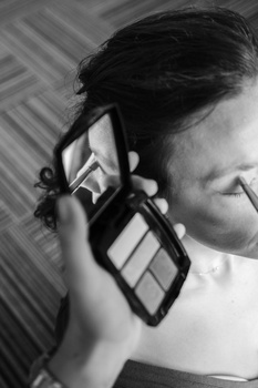 Black and white portrait of a person holding a light meter up to their face during a metering reading.