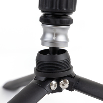 Close-up of tripod head with metal quick-release plate and black threaded connection collar.