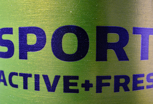 Close-up of product label with bold blue text reading "SPORT" and "ACTIVE+FRESH" on a green and tan gradient background.
