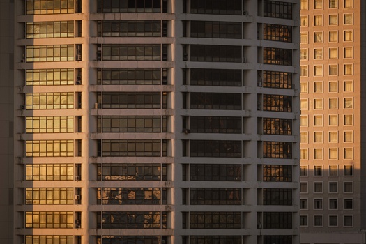 Four residential high-rise buildings photographed at golden hour with warm light illuminating their facades.