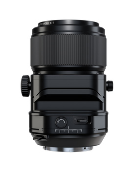 Black tilt-shift lens with focus ring and adjustment knobs mounted vertically against white background.