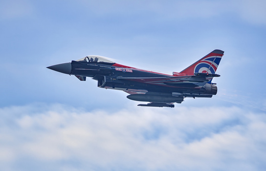 Royal Air Force Eurofighter Typhoon jet aircraft in flight against a partly cloudy sky.