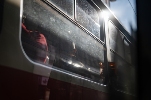 Sunlight streaming through bus windows with condensation and interior reflections visible.