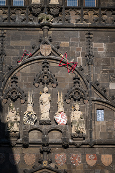 Ornate Gothic stone architectural detail with carved figures in recessed niches and decorative arches.