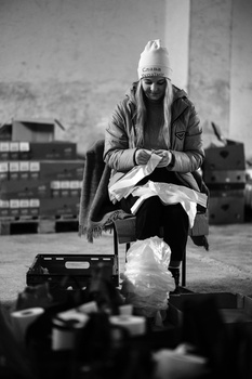 Musician sitting on rooftop holding instrument in black and white portrait.