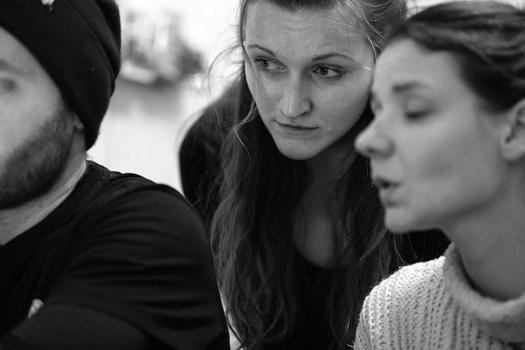 Three people in close proximity looking toward the camera in a black and white portrait.