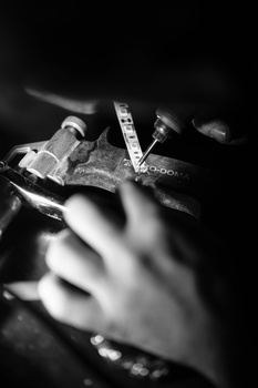 Blurred hands holding a camera with visible text on the strap against a dark background.