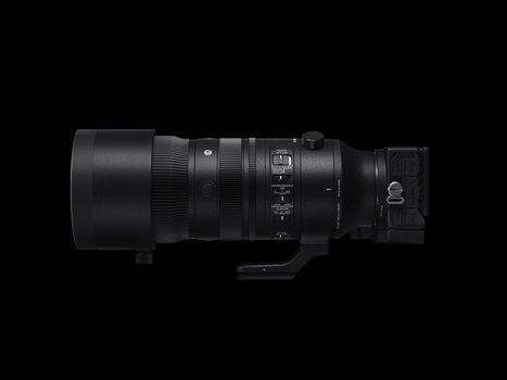 Side view of a professional telephoto lens with focus ring and AF/MF switch against black background.